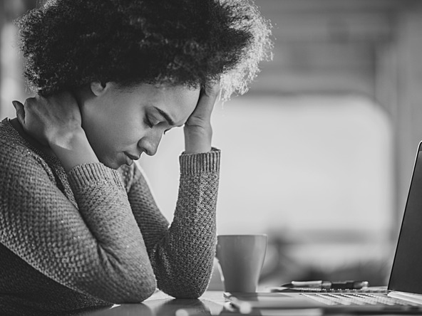 black and white photo of worried woman infront of laptop